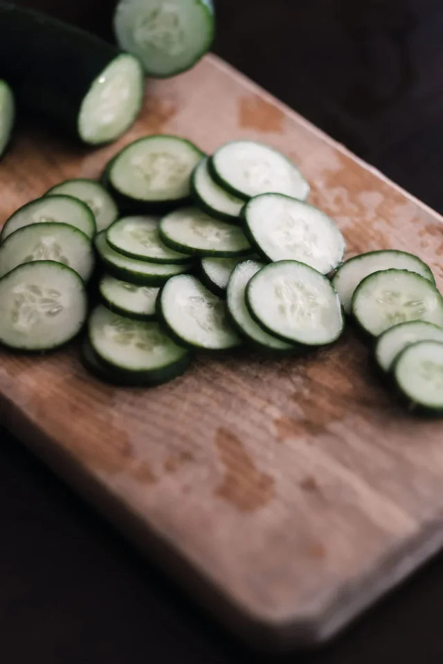 Freshly sliced cucumber on a wooden cutting board